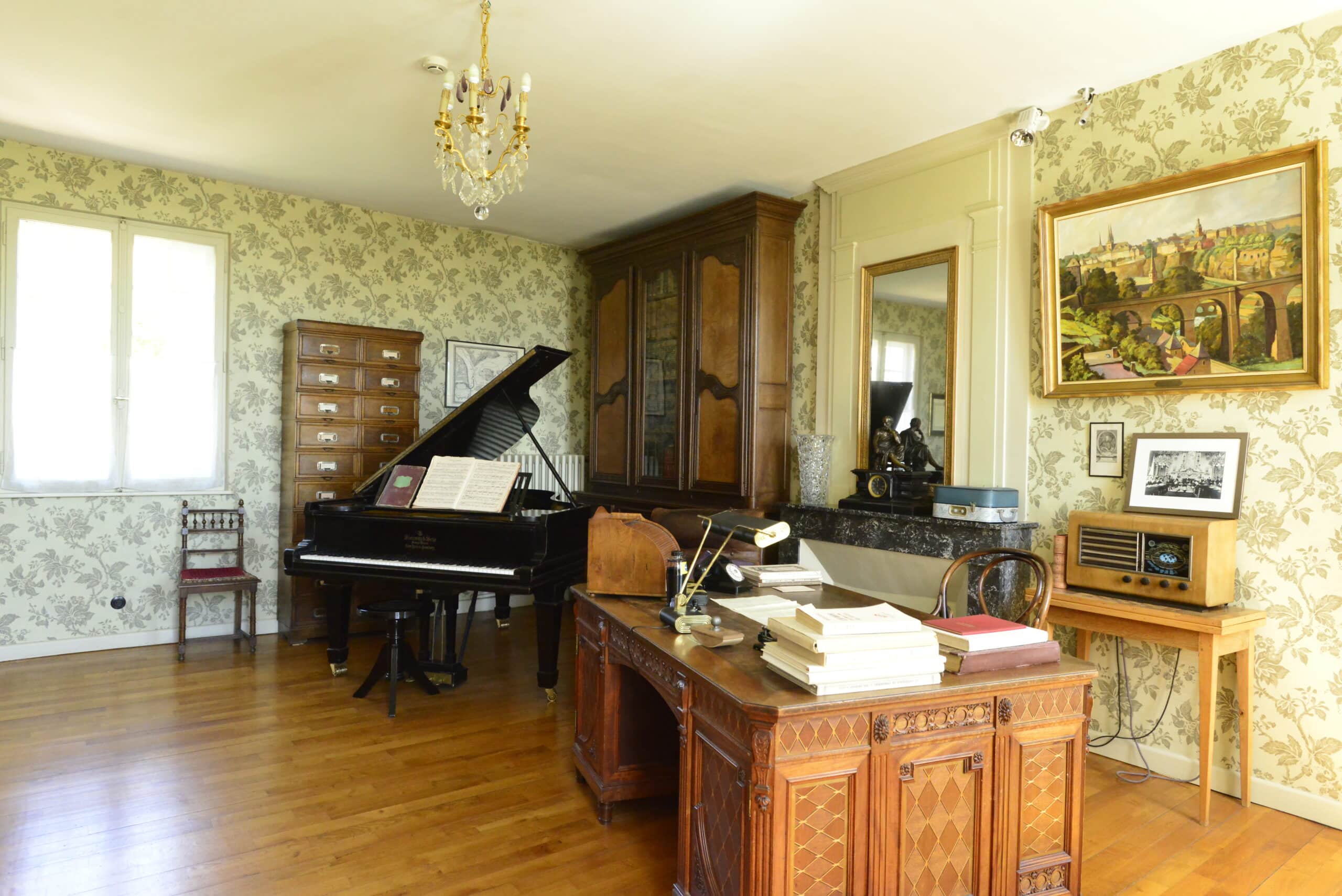 Autre angle de vue d'une pièce de la maison de Robert Schuman avec un piano et un bureau